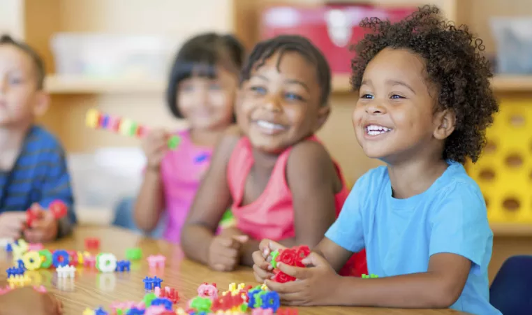 Smiling kids playing around table